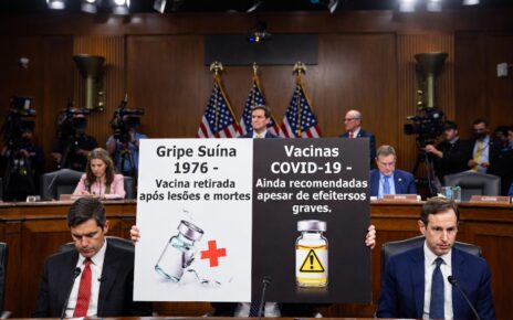 Uma foto 1280 x 720 baseada nessa notícia de audiencia do senado dos eua: "Ao contrário da vacina contra a gripe suína de 1976, que foi retirada do mercado após a cobertura da mídia sobre lesões e mortes, as vacinas contra a COVID-19 continuam sendo amplamente recomendadas, apesar das crescentes evidências de efeitos adversos graves"